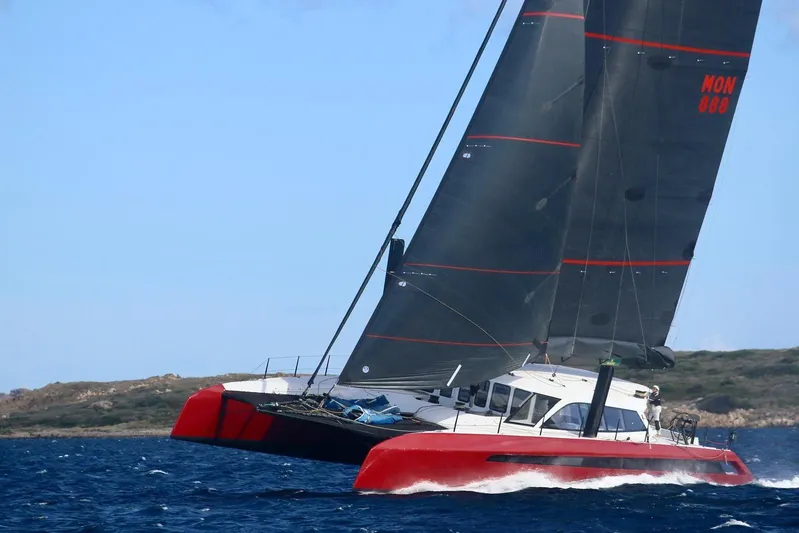 Highland Fling 18 Yacht Photos Pics 2023 Gunboat 80 sailing catamaran with red hull and black sails on open water.