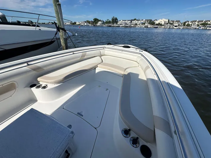 Block It Out Yacht Photos Pics 2005 Boston Whaler 320 Outrage boat interior with seating, docked by calm waters.