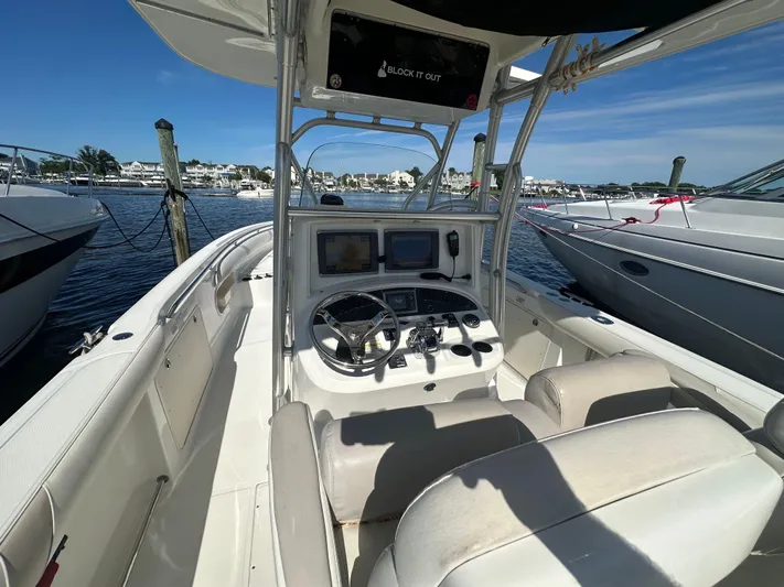 Block It Out Yacht Photos Pics 2005 Boston Whaler 320 Outrage boat interior with steering console, docked at marina.