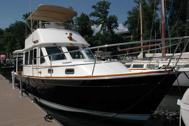 Eight Bells Yacht Photos Pics 2006 Sabre 36 Flybridge Sedan docked at marina, surrounded by trees and other boats.
