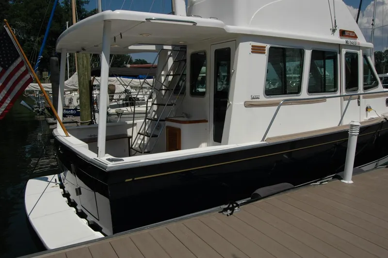 Eight Bells Yacht Photos Pics 2006 Sabre 36 Flybridge Sedan docked, featuring sleek design and American flag.