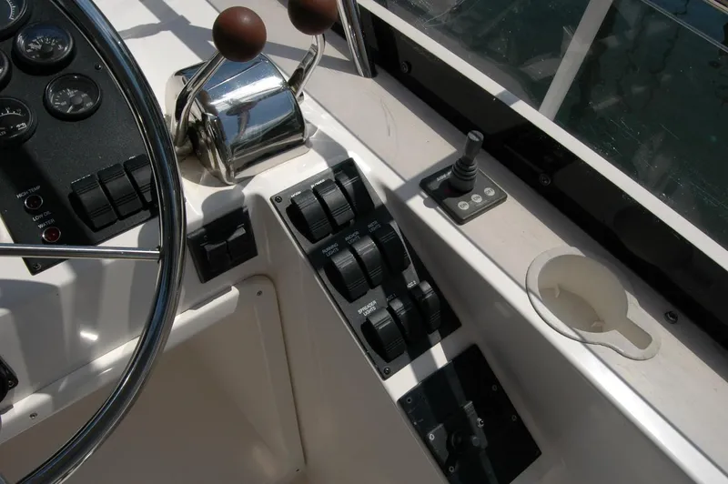 Eight Bells Yacht Photos Pics Control panel of 2006 Sabre 36 Flybridge Sedan with steering wheel and throttle levers.