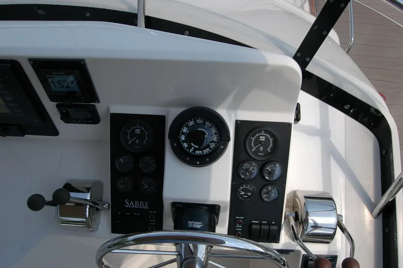 Eight Bells Yacht Photos Pics Control panel of 2006 Sabre 36 Flybridge Sedan with gauges and steering wheel.