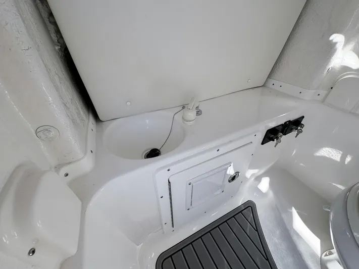  Yacht Photos Pics 2023 Tidewater 282cc Adventure Bluewater boat interior, featuring storage compartment and clean white finish.