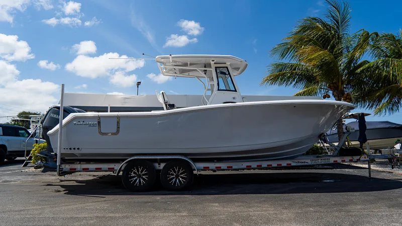  Yacht Photos Pics 2023 Tidewater 282cc Adventure Bluewater boat on trailer, parked under a clear blue sky.