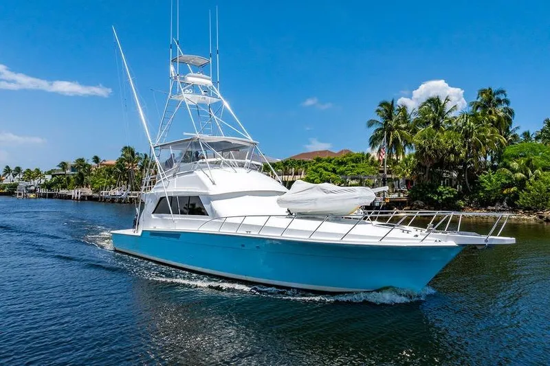 Energy Yacht Photos Pics 1998 Bertram Convertible yacht cruising on a tropical waterway with palm trees.
