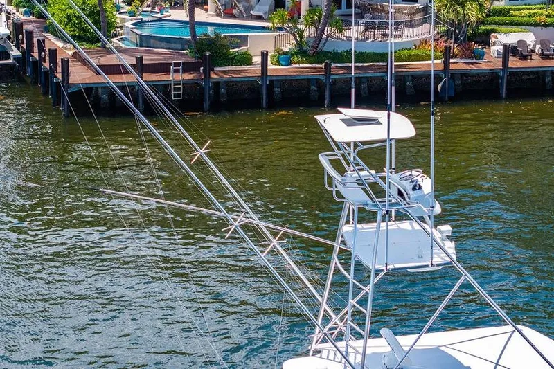 Energy Yacht Photos Pics 1998 Bertram Convertible yacht with tower, docked near waterfront property with pool.