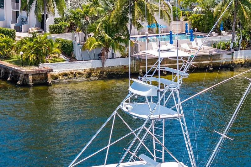 Energy Yacht Photos Pics 1998 Bertram Convertible yacht near waterfront property with palm trees and pool.
