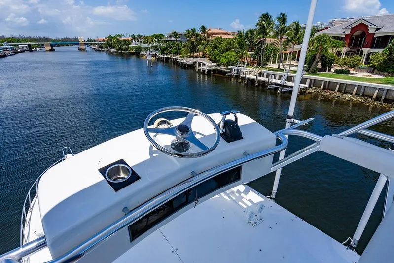 Energy Yacht Photos Pics 1998 Bertram Convertible yacht steering deck overlooking scenic waterfront homes.
