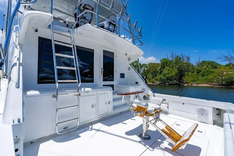 Energy Yacht Photos Pics 1998 Bertram Convertible yacht deck with fishing chair, ladder, and scenic water view.