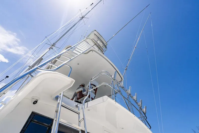 Energy Yacht Photos Pics 1998 Bertram Convertible yacht against clear blue sky, showcasing sleek design and structure.