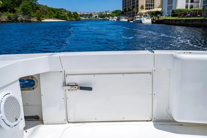 Energy Yacht Photos Pics 1998 Bertram Convertible boat on a scenic waterway with lush greenery and buildings.