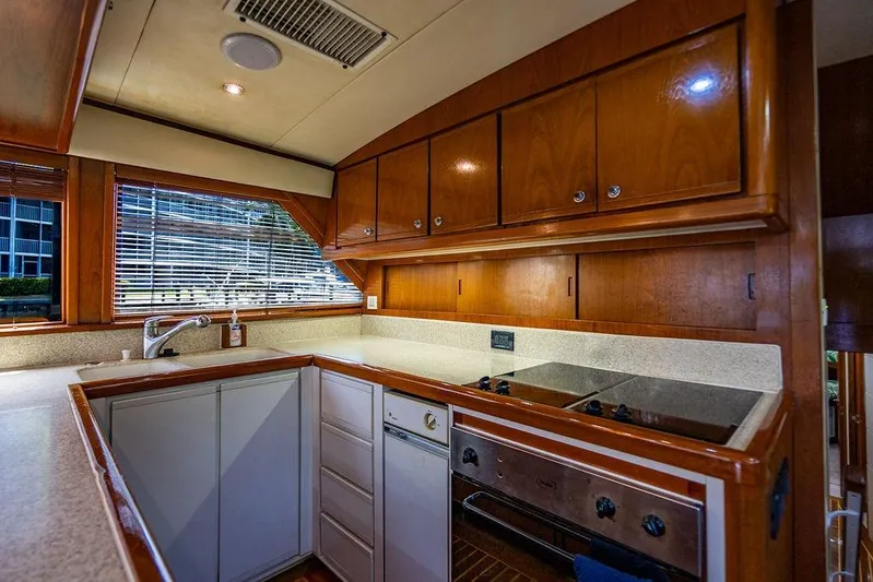 Energy Yacht Photos Pics 1998 Bertram Convertible yacht kitchen with wooden cabinets and modern appliances.