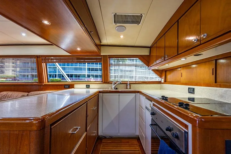 Energy Yacht Photos Pics Luxurious kitchen interior of a 1998 Bertram Convertible yacht with wooden cabinetry.