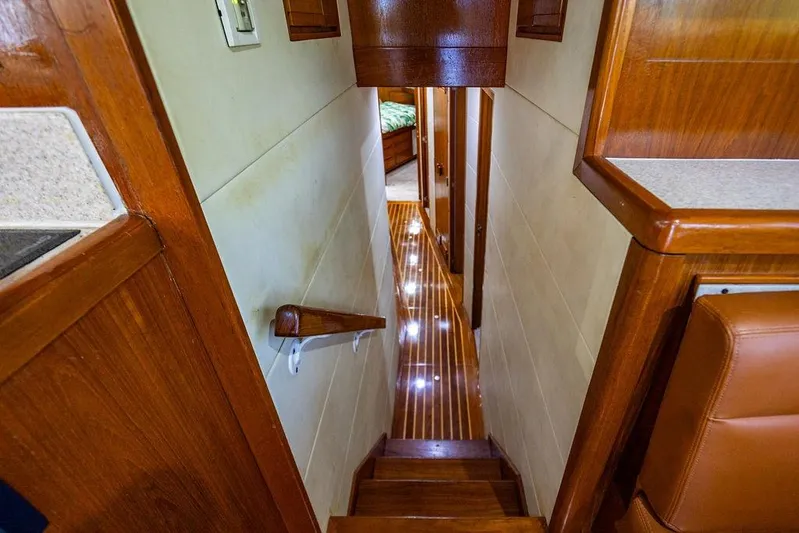 Energy Yacht Photos Pics Interior of 1998 Bertram Convertible yacht with polished wood and illuminated hallway.