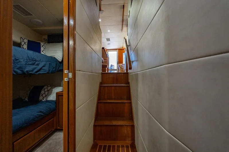 Energy Yacht Photos Pics Interior of 1998 Bertram Convertible yacht with wooden stairs and cozy bunk beds.