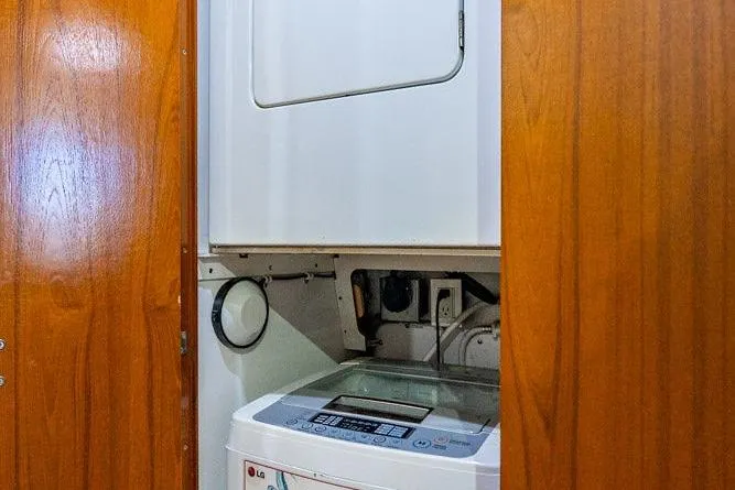 Energy Yacht Photos Pics 1998 Bertram Convertible interior with LG washing machine in wooden cabinet.