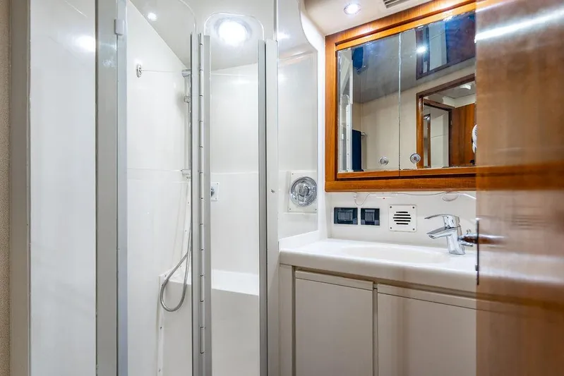 Energy Yacht Photos Pics 1998 Bertram Convertible yacht bathroom with shower, sink, and mirror.