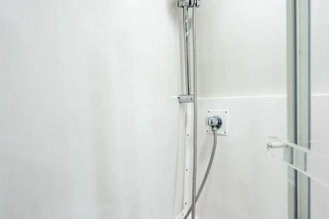 Energy Yacht Photos Pics Shower area in 1998 Bertram Convertible boat, featuring sleek chrome fixtures.