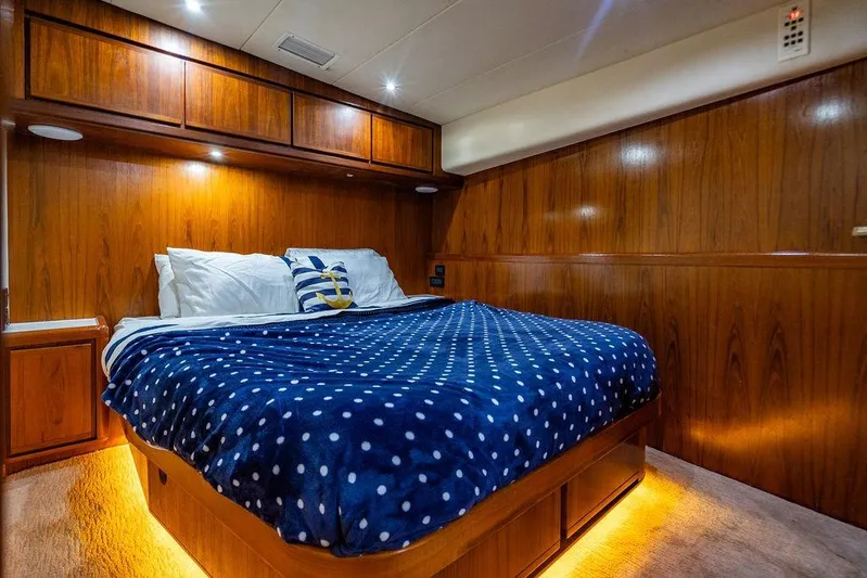 Energy Yacht Photos Pics Luxurious 1998 Bertram Convertible yacht bedroom with wood paneling and cozy bedding.