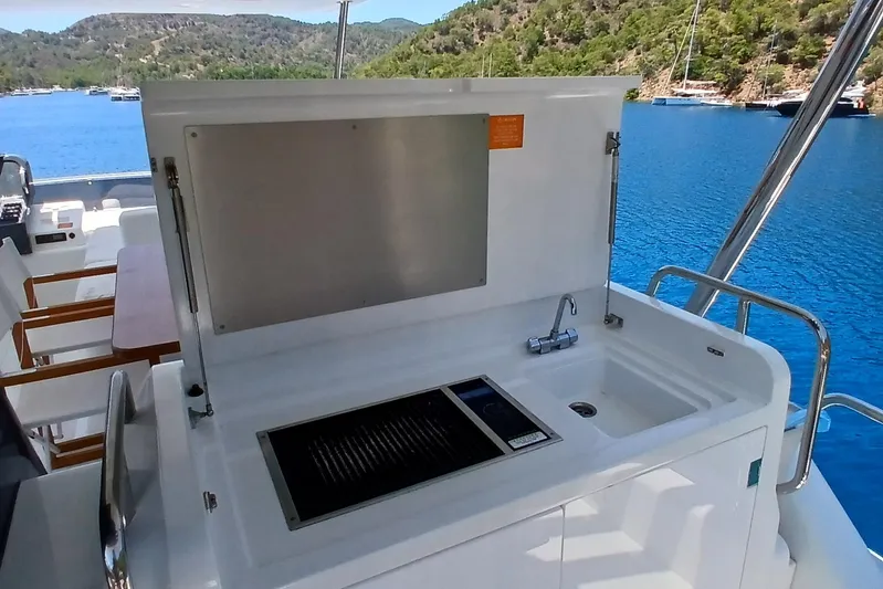  Yacht Photos Pics Outdoor kitchen on 2022 Sirena 58 yacht with sink and grill, overlooking scenic bay.