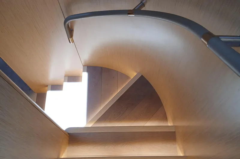  Yacht Photos Pics Curved wooden staircase with modern railing on a 2022 Sirena 58 yacht.