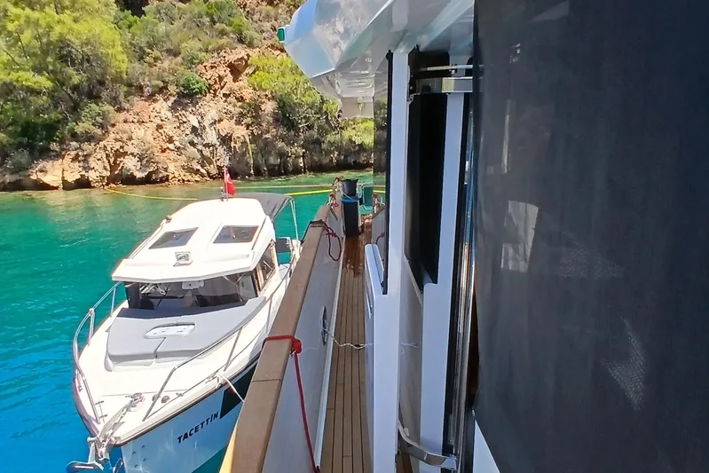  Yacht Photos Pics Sirena 58 yacht docked in turquoise waters near rocky shoreline, 2022 model.