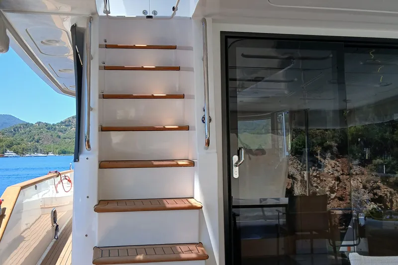  Yacht Photos Pics Staircase on 2022 Sirena 58 yacht with scenic ocean and mountain view.