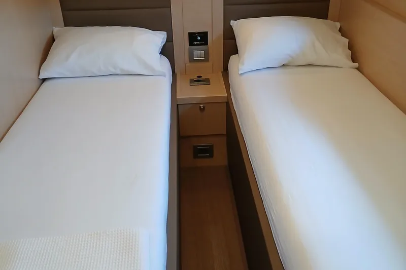  Yacht Photos Pics Twin beds in a 2022 Sirena 58 yacht cabin, featuring modern design and comfort.
