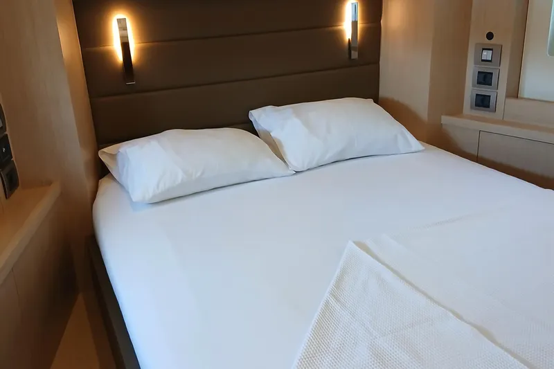  Yacht Photos Pics Luxurious bedroom interior of 2022 Sirena 58 yacht with modern lighting and plush bedding.