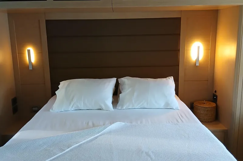  Yacht Photos Pics Luxurious Sirena 58 yacht bedroom interior, 2022 model, featuring cozy bed and ambient lighting.
