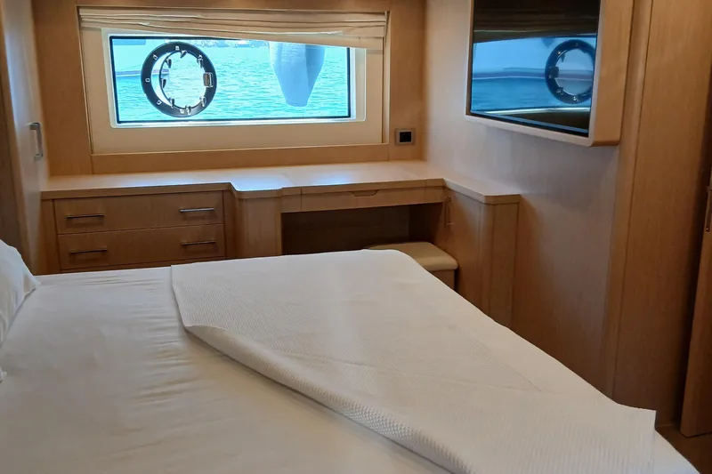  Yacht Photos Pics Luxurious cabin interior of 2022 Sirena 58 yacht with bed, window, and wooden furnishings.