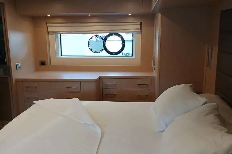  Yacht Photos Pics Luxurious cabin interior of 2022 Sirena 58 yacht with bed and porthole window.