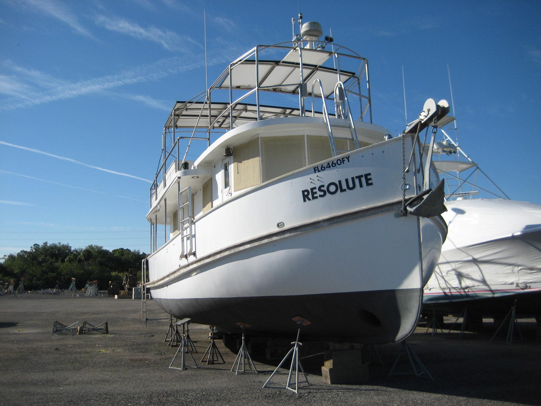 1987 Custom Pilgrim Tribute boat "Resolute" on dry dock under clear blue sky.