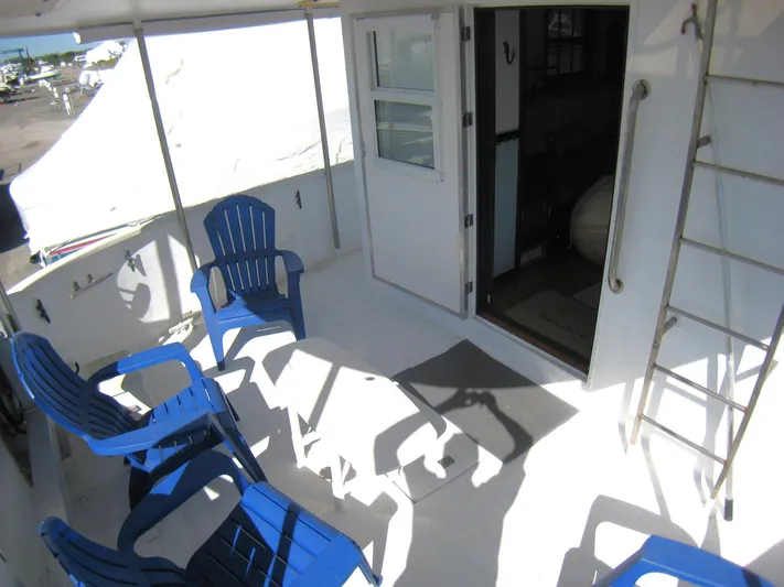 Resolute Yacht Photos Pics Deck of 1987 Custom Pilgrim Tribute boat with blue chairs and open cabin door.