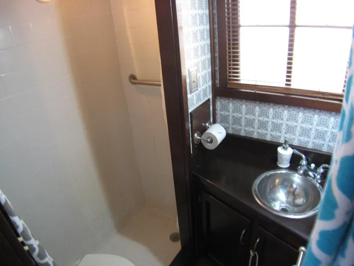 Resolute Yacht Photos Pics Compact bathroom in 1987 Custom Pilgrim Tribute with shower, sink, and window blinds.