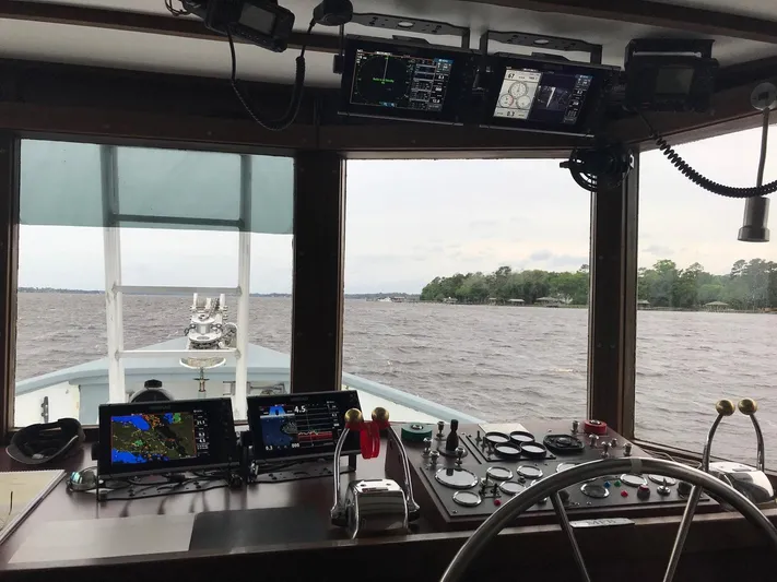 Resolute Yacht Photos Pics Pilgrim Tribute 1987 boat cockpit with navigation equipment, steering wheel, and water view.