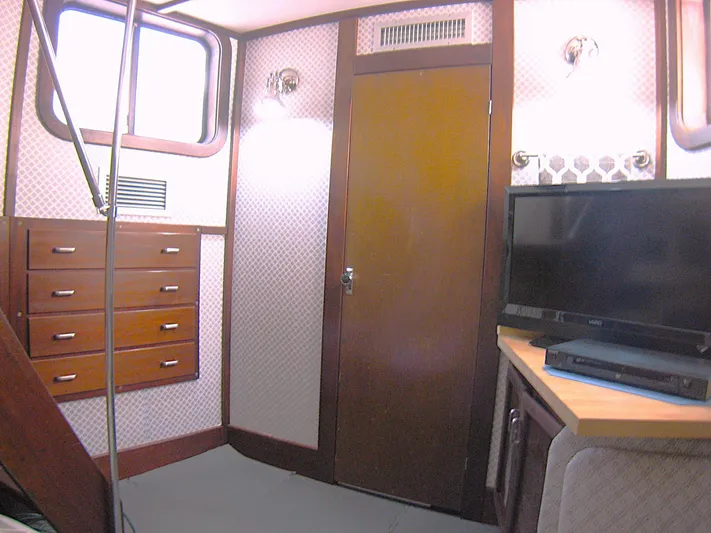 Resolute Yacht Photos Pics Interior of 1987 Custom Pilgrim Tribute boat with TV, drawers, and wood paneling.