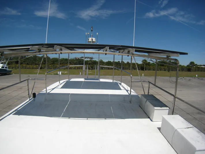 Resolute Yacht Photos Pics 1987 Custom Pilgrim Tribute boat with spacious deck and canopy, set against a clear blue sky.