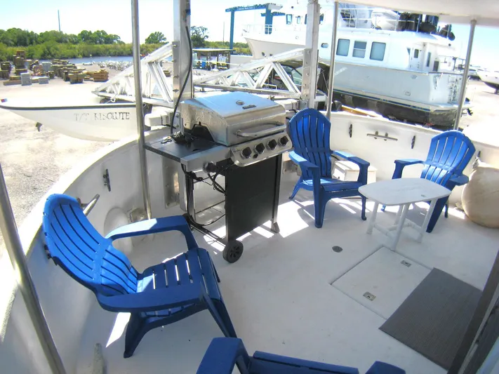 Resolute Yacht Photos Pics Outdoor deck of 1987 Custom Pilgrim Tribute with blue chairs and grill.