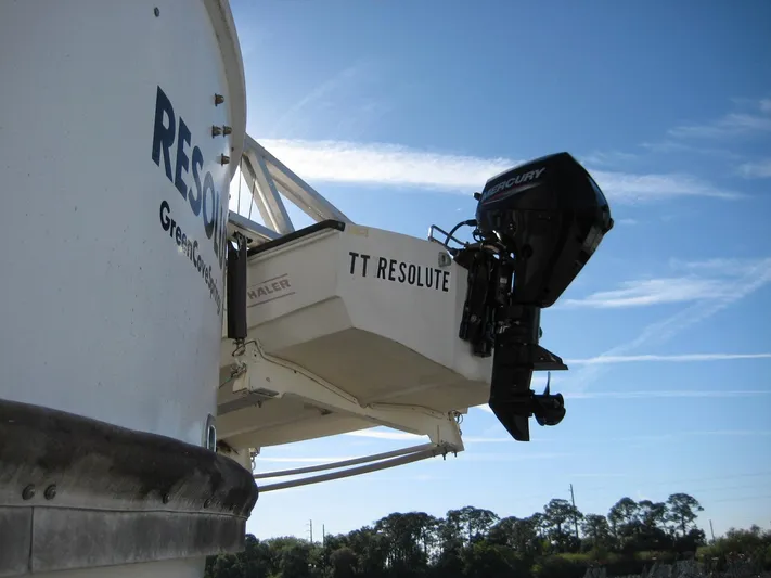 Resolute Yacht Photos Pics Boat with Mercury outboard motor, labeled "TT Resolute," under clear blue sky.
