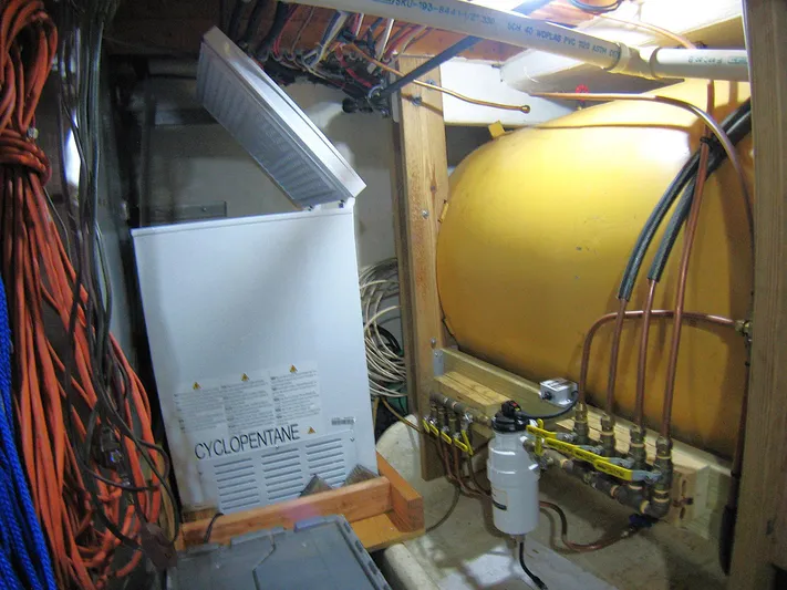 Resolute Yacht Photos Pics A 1987 Custom Pilgrim Tribute engine room with a yellow tank and various cables.