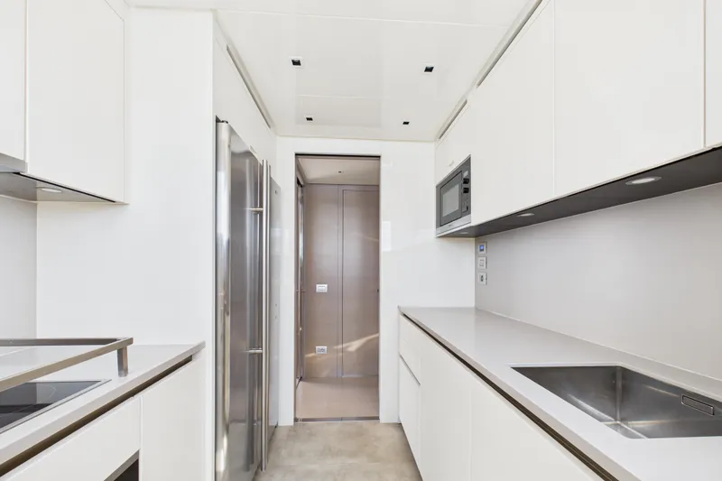  Yacht Photos Pics Modern kitchen interior on 2018 Sanlorenzo SL86 yacht, featuring sleek white cabinetry and stainless steel appliances.