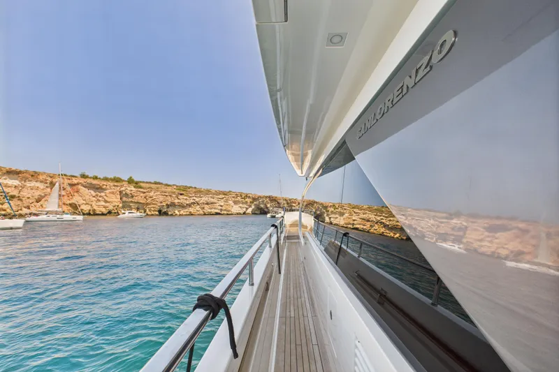  Yacht Photos Pics Sanlorenzo SL86 yacht, 2018 model, cruising near rocky coastline with clear blue water.