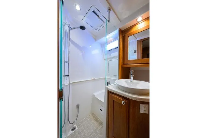  Yacht Photos Pics Luxurious bathroom in 2022 Sabre 45 Salon Express yacht with modern fixtures and wooden cabinetry.