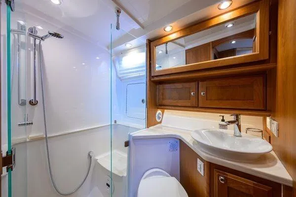  Yacht Photos Pics Luxurious bathroom in 2022 Sabre 45 Salon Express yacht with modern fixtures and wood cabinetry.