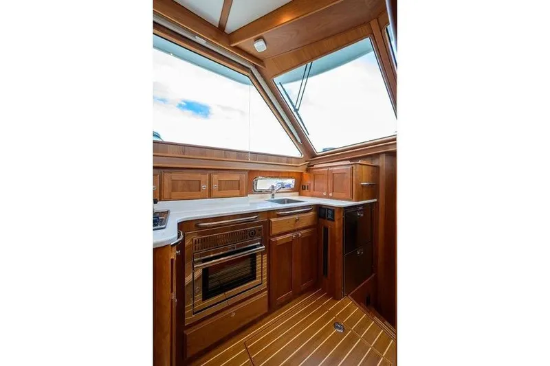  Yacht Photos Pics Interior of 2022 Sabre 45 Salon Express yacht with wooden cabinetry and modern appliances.