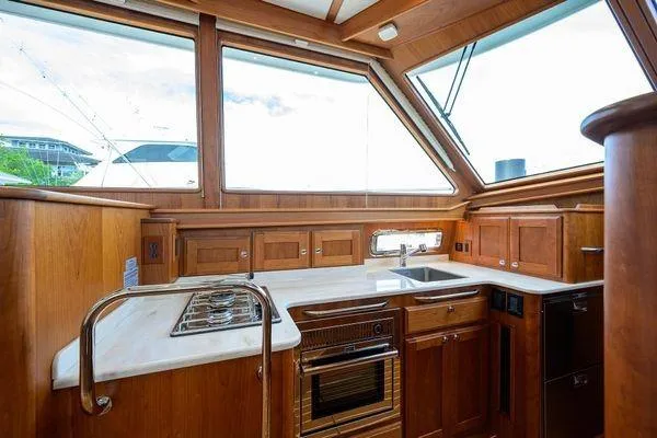  Yacht Photos Pics Interior of 2022 Sabre 45 Salon Express yacht, featuring a modern kitchen with wooden cabinetry.