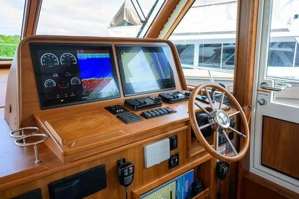  Yacht Photos Pics 2022 Sabre 45 Salon Express helm with modern navigation displays and wooden steering wheel.