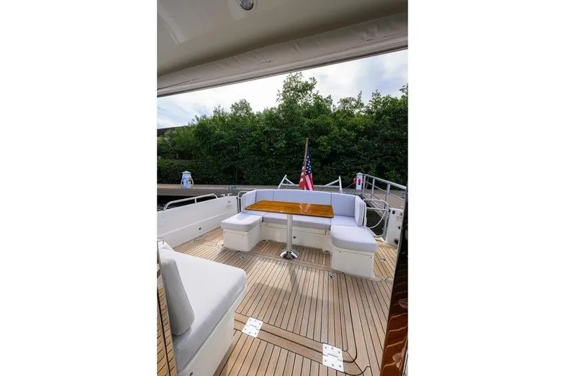  Yacht Photos Pics 2022 Sabre 45 Salon Express yacht deck with seating and table, featuring American flag.